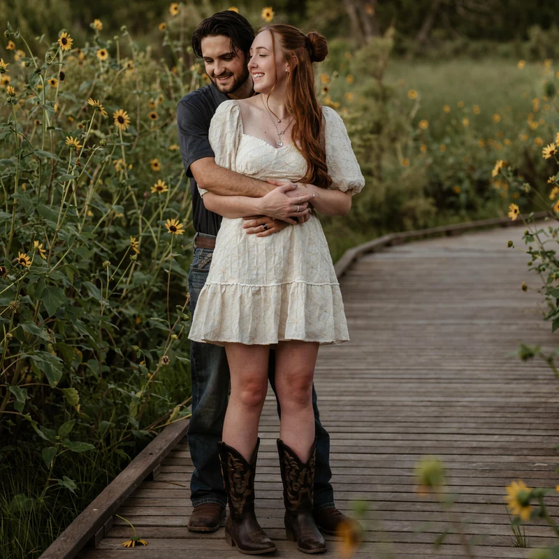Abby and Collin embracing among sunflowers